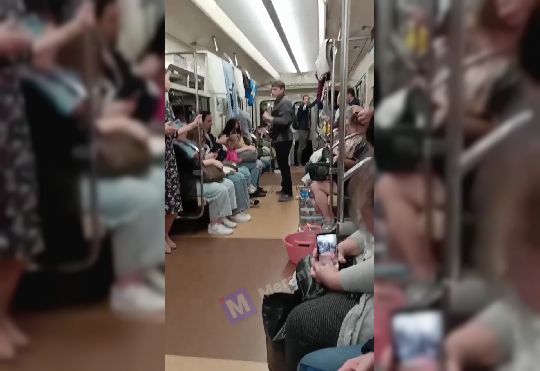 Молодой человек с тазиком развесил белье на поручнях вагона петербургского метро