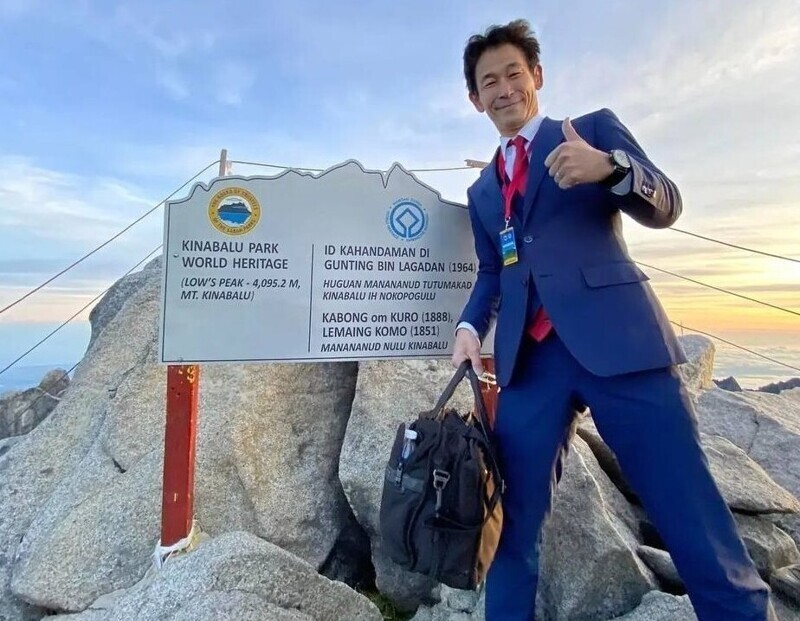 Японец покоряет горы в костюме-тройке, чтобы отрекламировать свой портняжный бизнес