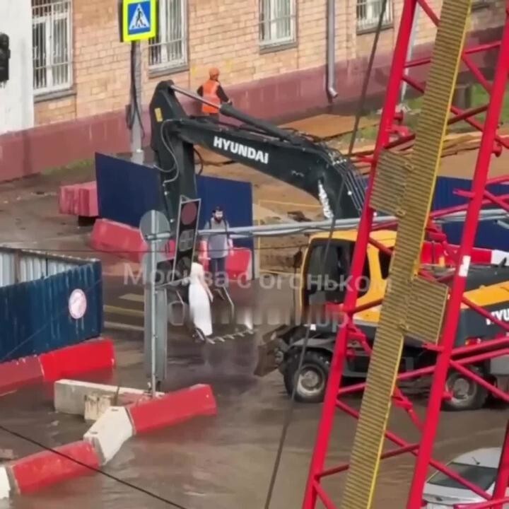 Водитель экскаватора перенёс девушку через лужу в ковше после ливня в Москве