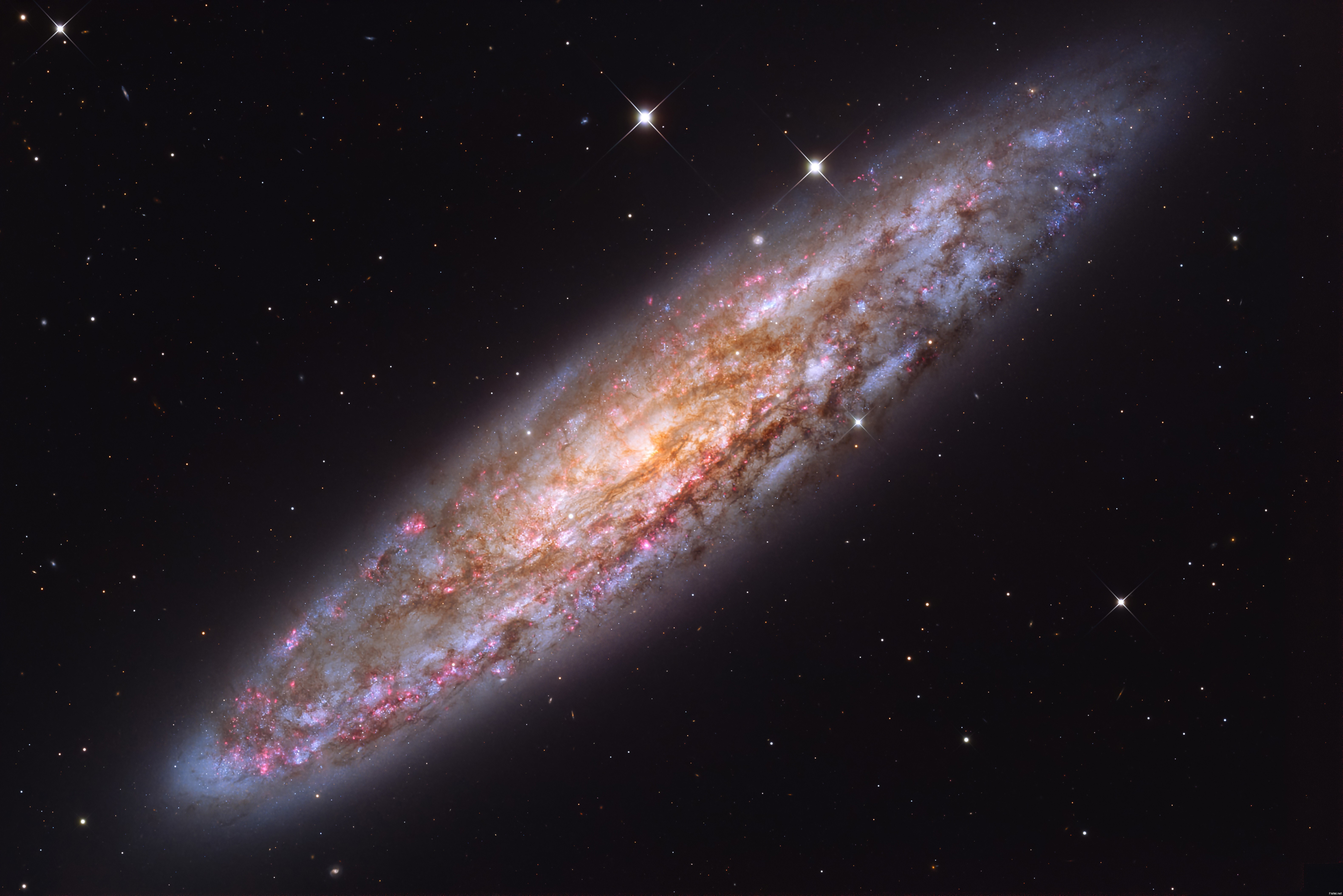 Блестящая NGC 253 — одна из самых ярких спиральных галактик, которые мы видим...