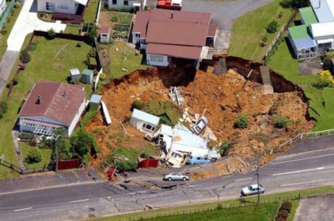 houses and cars in large Sinkhole  