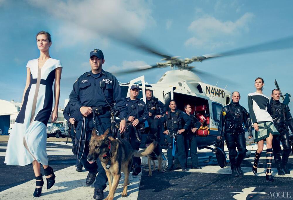 Oddly placed models in couture walking beside first responders