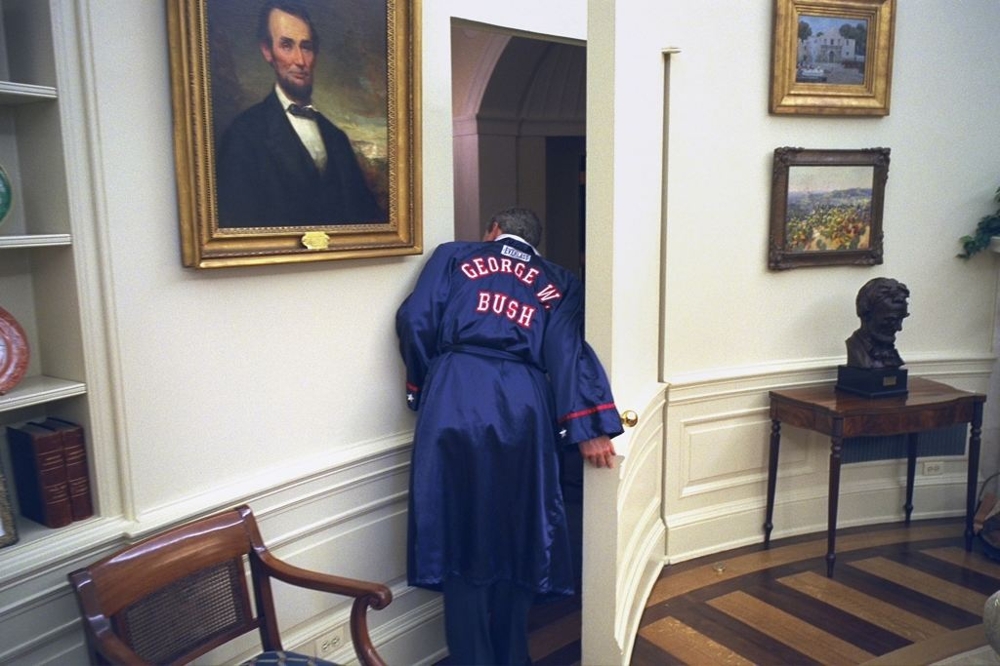 George W. Bush Looks around to show off a new robe he got as a  gift 