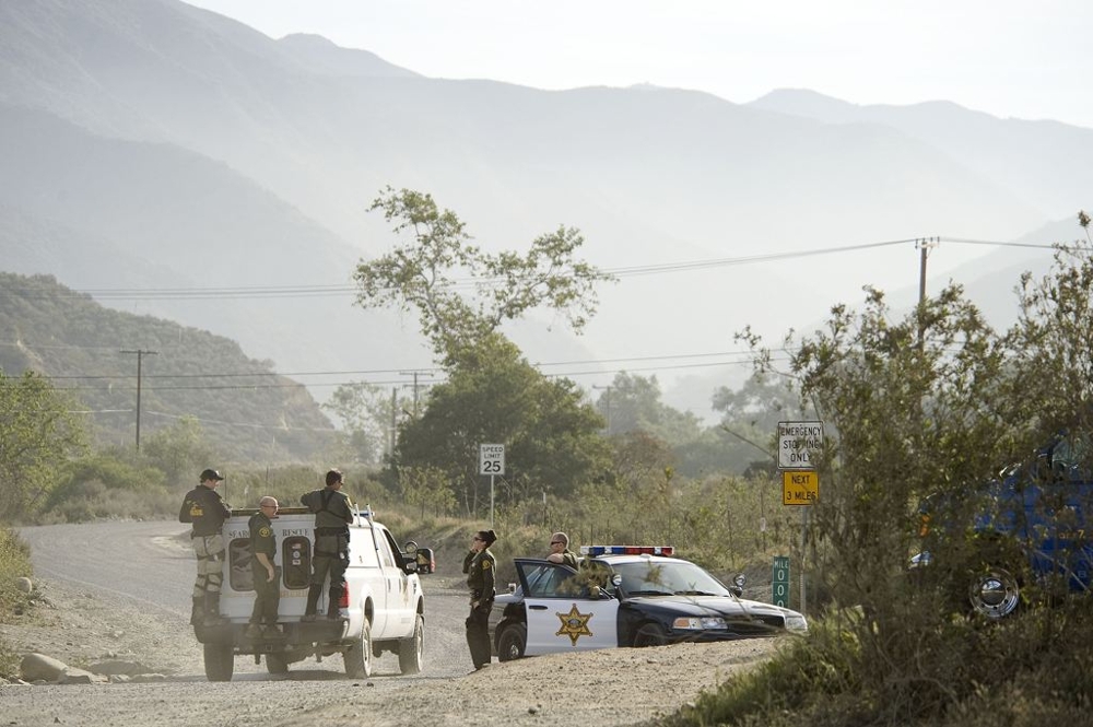 Rescuers drive past an Orange County Sheriff's road block