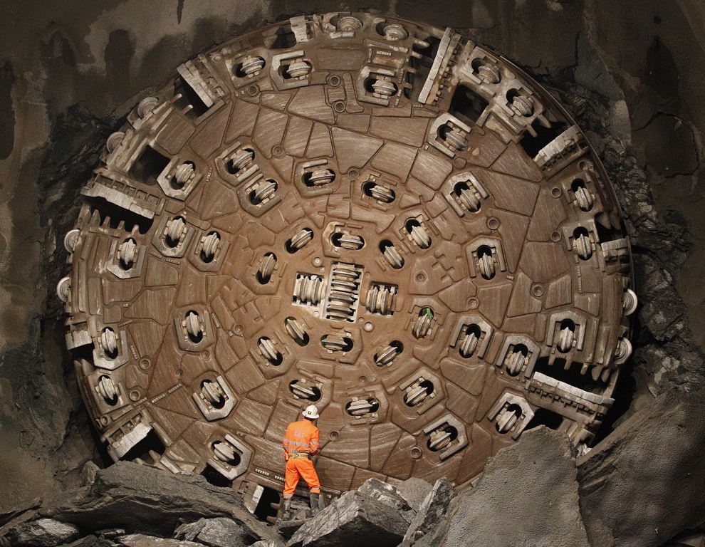 A miner stands in front of the drill machine