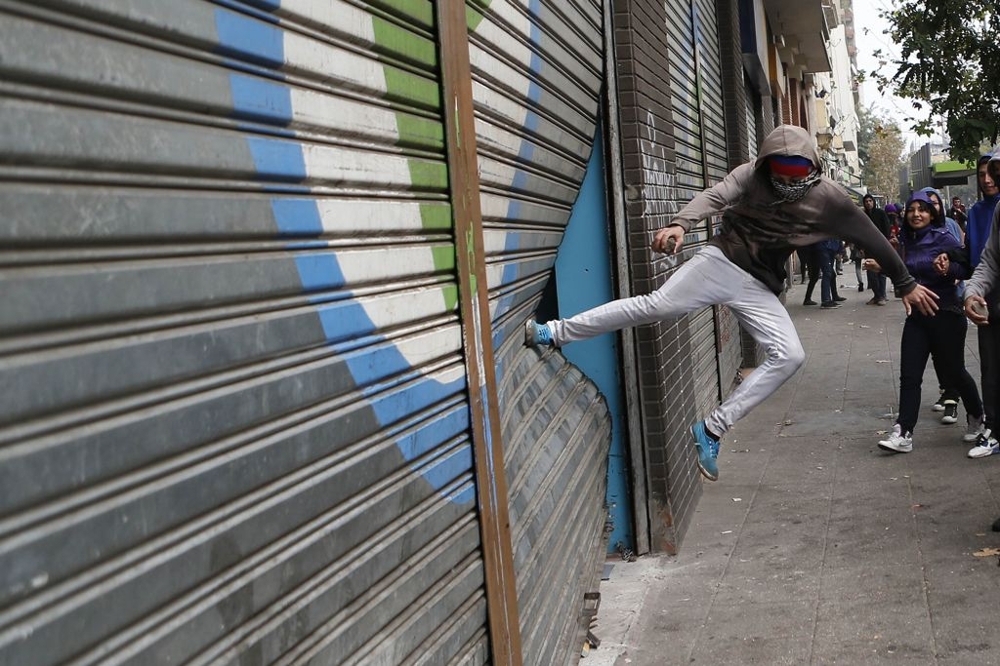 A Student kicking in store shutters 