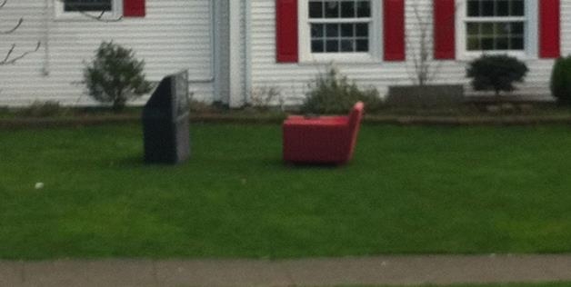TV and chair on front lawn 