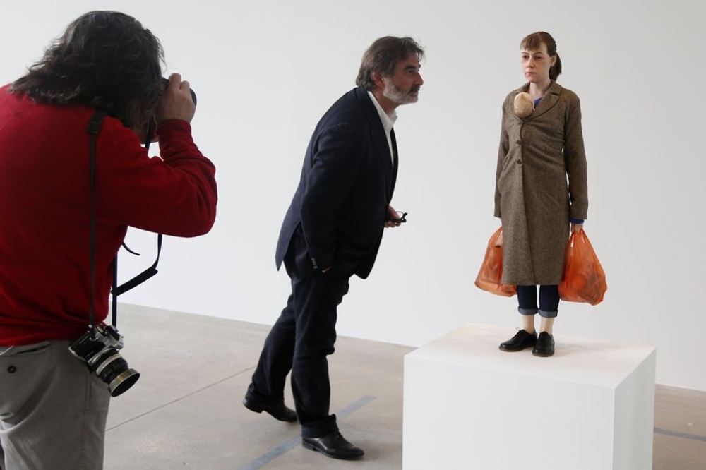 A visitor looks at a sculpture entitled "Woman with Shopping, 2013" by artist Ron Mueck