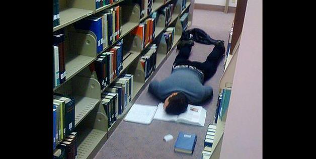 That book must have been very boring. No better place to sleep than on the library floor. 
