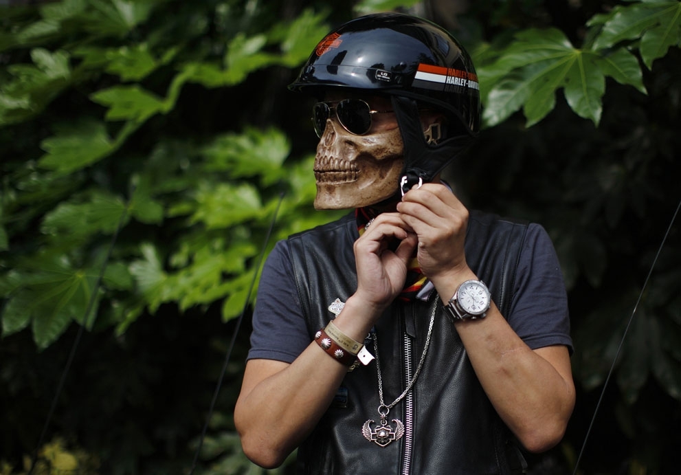 A man wearing a skeleton mask prepares to ride his Harley Davidson motorcycle during the annual Harley Davidson National