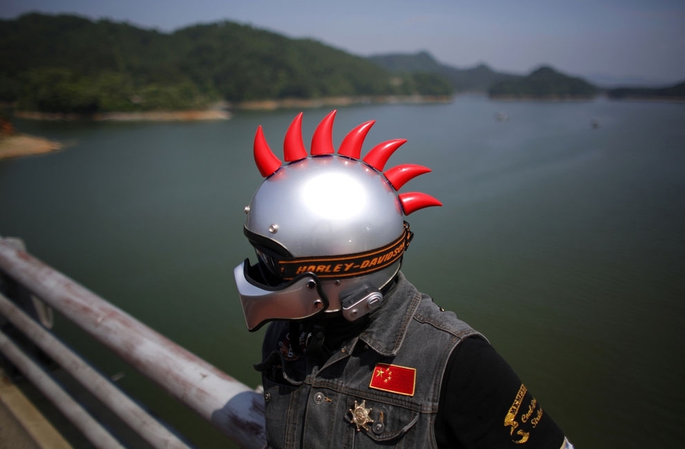 A Harley Davidson rider with decorated helmet takes a break in Zhejiang Province, on May 11, 2013. 