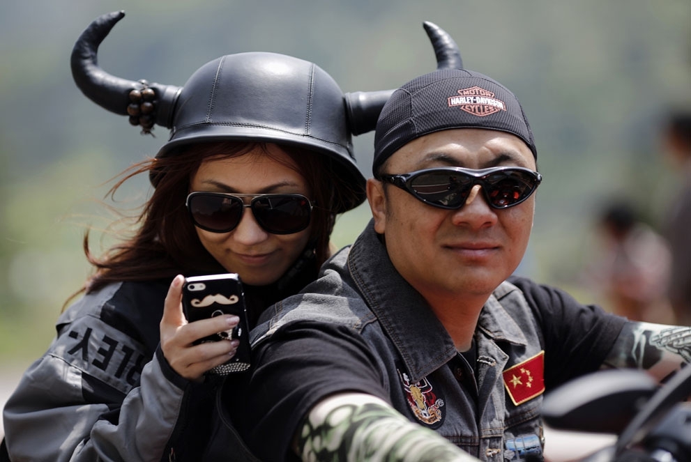 A couple rides a Harley Davidson motorcycle during the annual Harley Davidson National Rally in Qian Dao Lake, in Zhejia