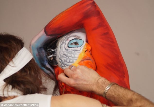 Artist paints woman's entire body to make her look like a parrot