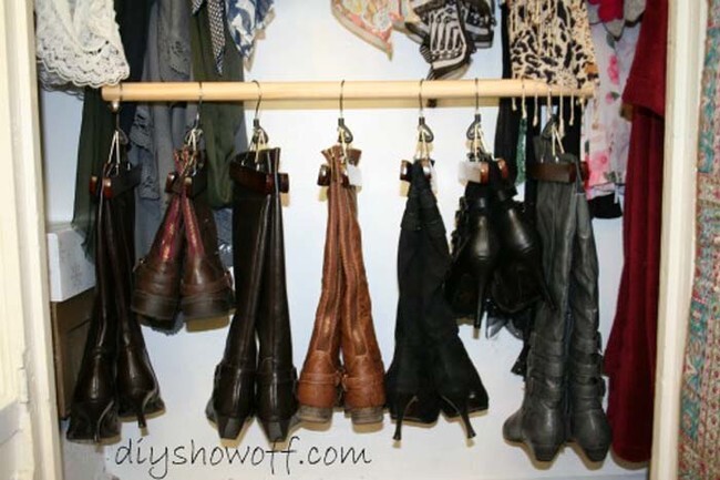 To keep tall boots off the floor and in shape, hang them from pant hangers.