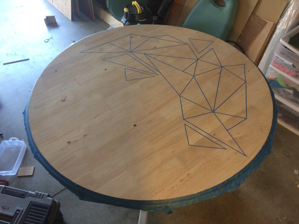 The coaster served as a straightedge, and he used the painter's tape to create shapes on the table.