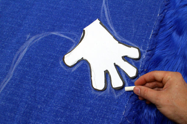 Using chalk, he traced the outline of one half of the Cookie Monster rug on the back side of the fabric.