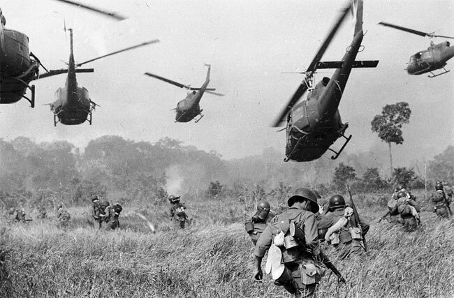 Hovering U.S. Army helicopters pour machine gun fire into the tree line to cover the advance of South Vietnamese ground troops in an attack on a Viet Cong camp 18 miles north of Tay Ninh, Vietnam, March 1965