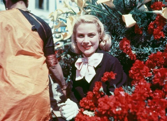 1955. Grace Kelly wearing white gloves and bow at the Cannes Film Festival.