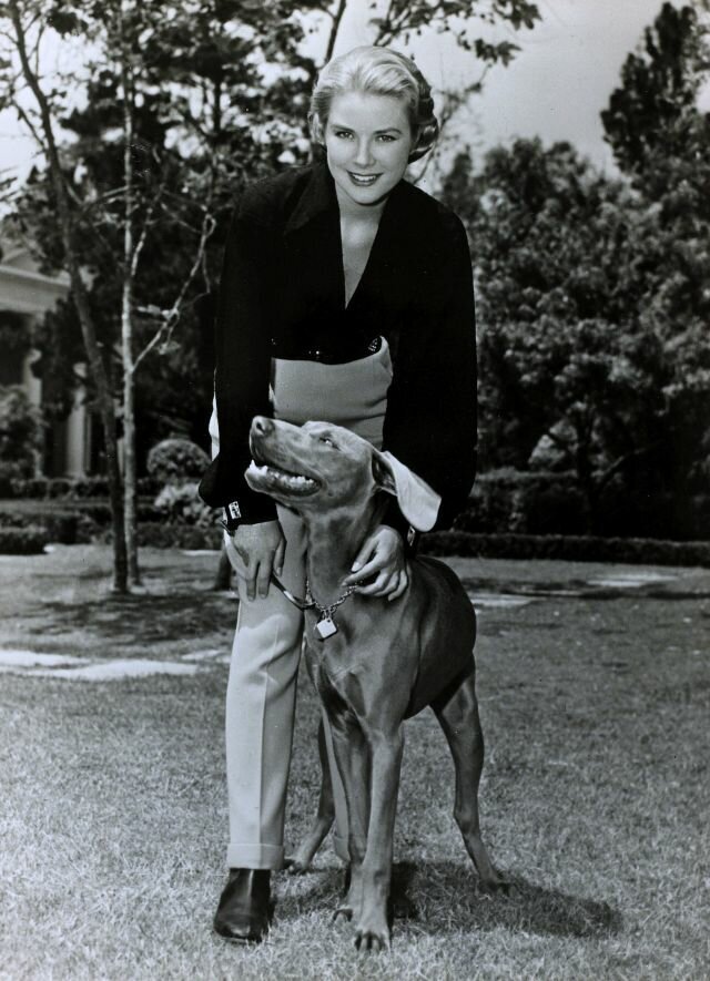 1954. Grace Kelly in chic tailored trousers with her dog.