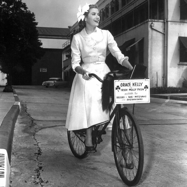 1954. Portrait of Grace Kelly on a bicycle.