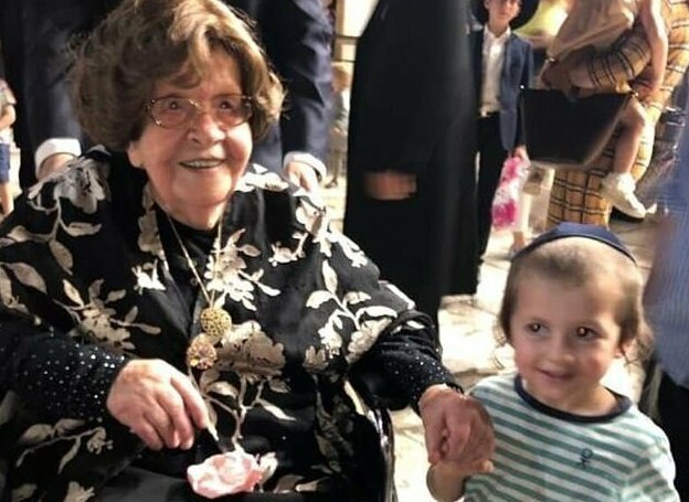 A happy Shoshana Ovitz clutching the hand of a family member at her 104th birthday celebrations