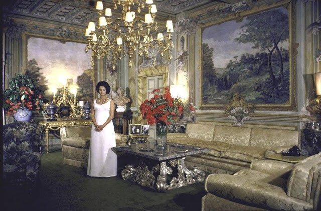 Formal picture of Sophia standing in the main living room of her villa.