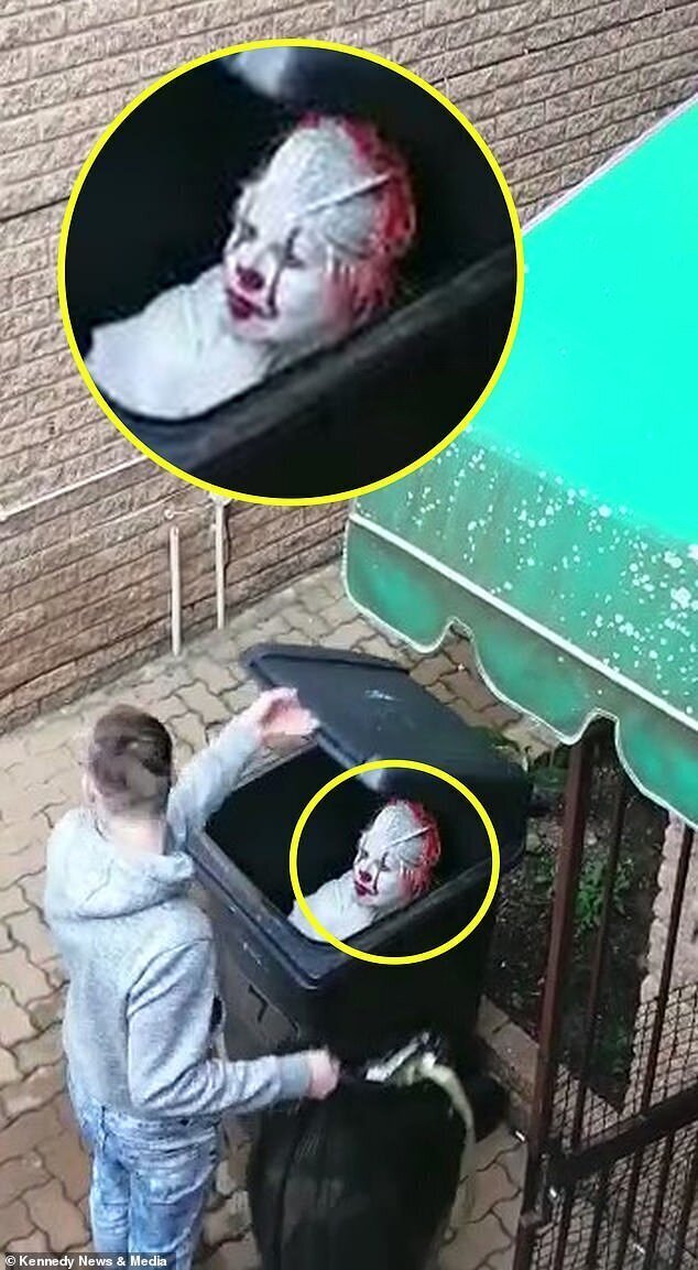Unsuspecting Ruan Becker, 20, opens the wheelie bin where his mother Hester Greeff, 41, is hiding dressed as Pennywise from the horror movie It in Johannesburg, South Africa