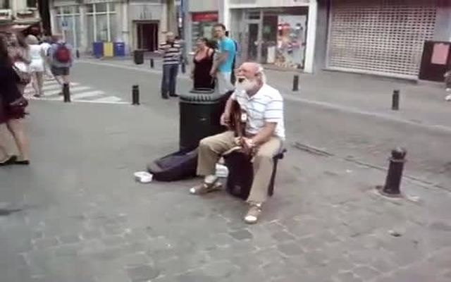 Крутой дед играет рок-н-ролл на улице 