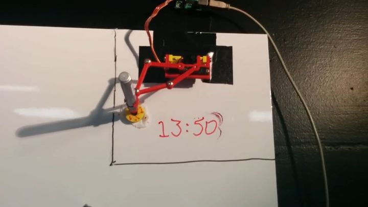 Робот-часовщик рисует время маркером на доске 