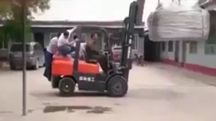 Китайские рабочие пытаются предотвратить переворот вилочного погрузчика 