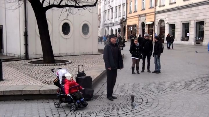 Уличный музыкант поет на углу улицы, но обратите внимание на ребенка в коляске 