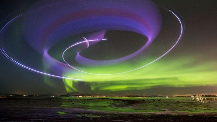 Захватывающий ночной полет на параплане на фоне зеленых волн северного сияния 
