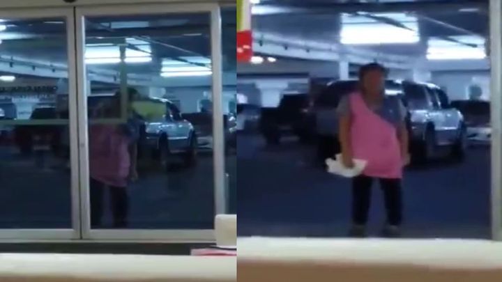 Уборщица пытается вымыть автоматические двери супермаркета  