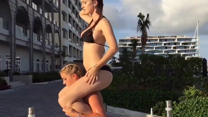 Симпатичная фитнес-модель Катарина Конов приседает с моделью Кассандрой Скотт на плечах 