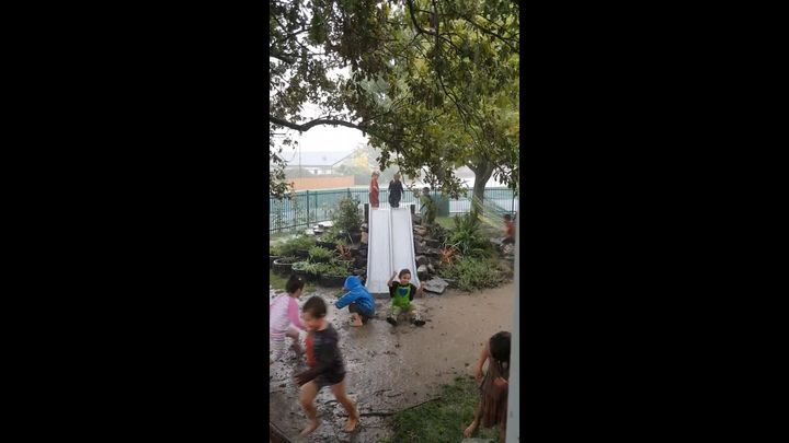 Детям погода не помеха! Новозеландская детвора скатывается с горки в грязь во время проливного дождя 