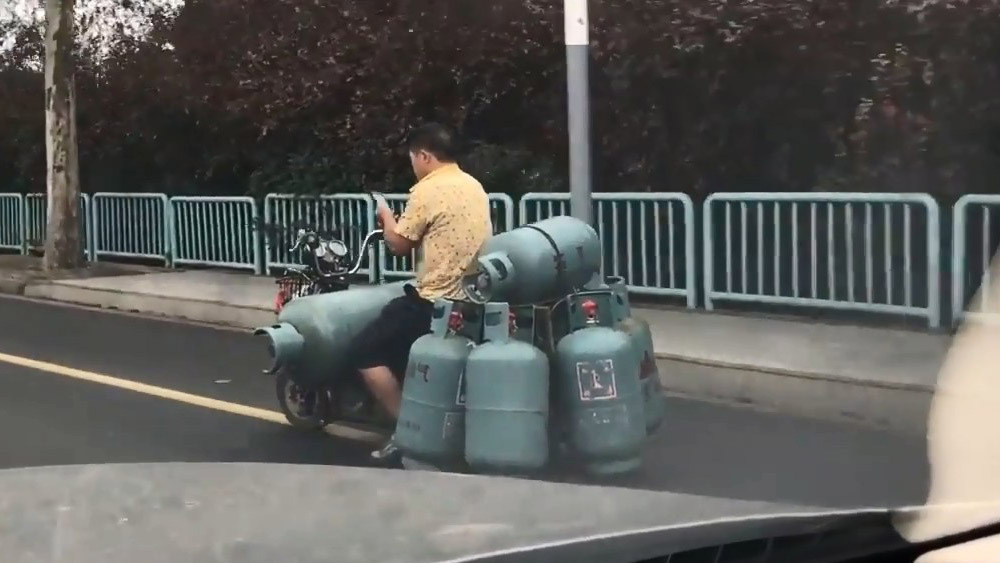 Китаец загрузил 7 газовых баллонов на свой скутер 