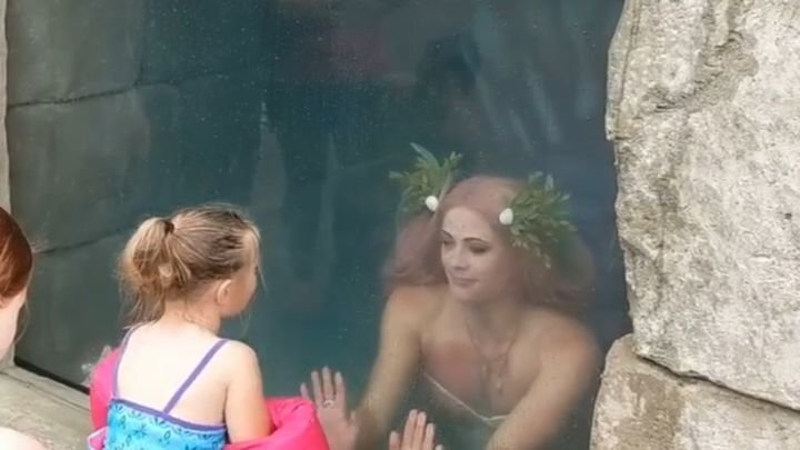 Девушка в костюме русалки развлекает малышню 