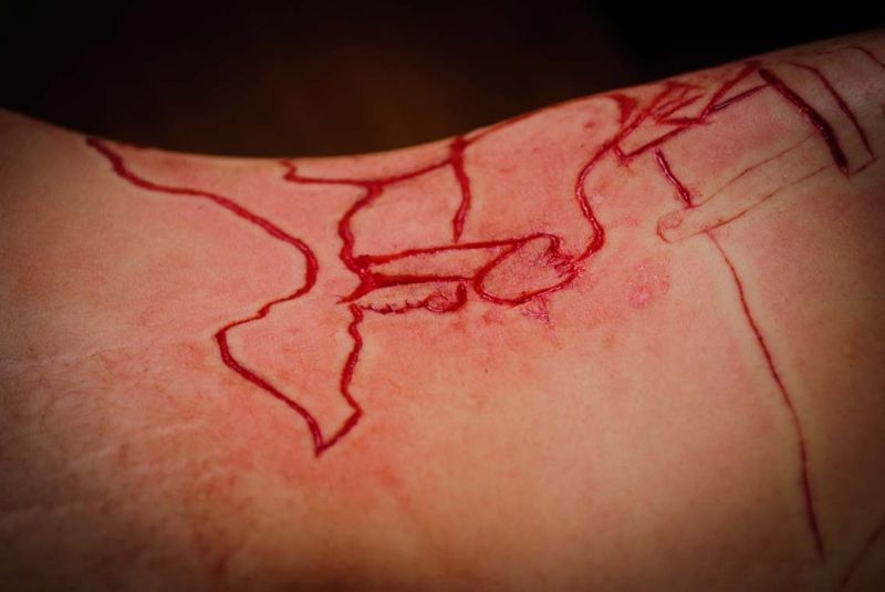 Татуировщик вырезал на теле клиента непонятный узор