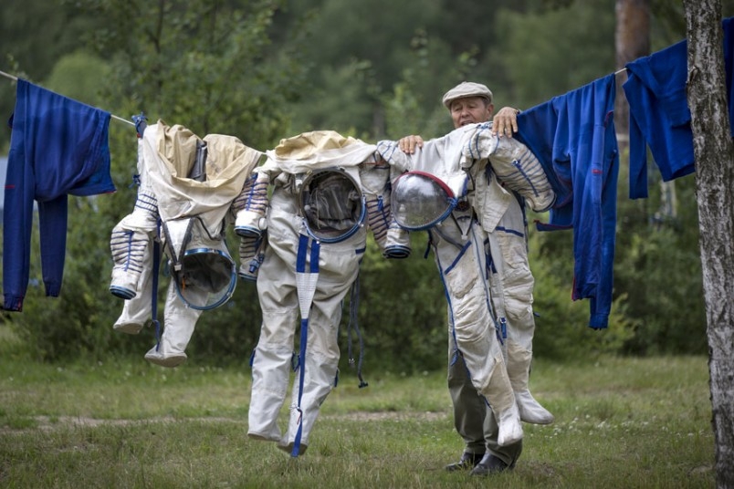 Развешивает костюмы космонавтов 