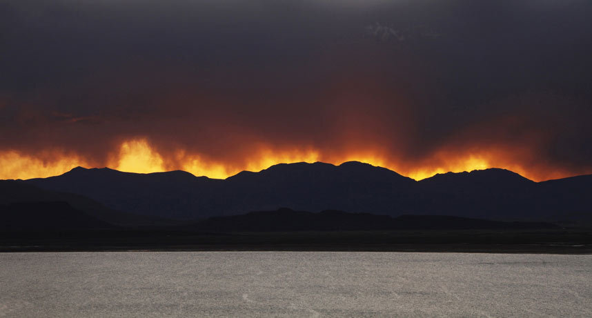 Огненный закат над кладбищем инков на берегу озера Умайо возле Пуно, Перу.