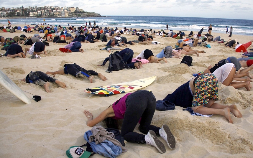 Более 400 человек засунули головы в песок австралийского пляжа Бонди Бич в Сиднее.