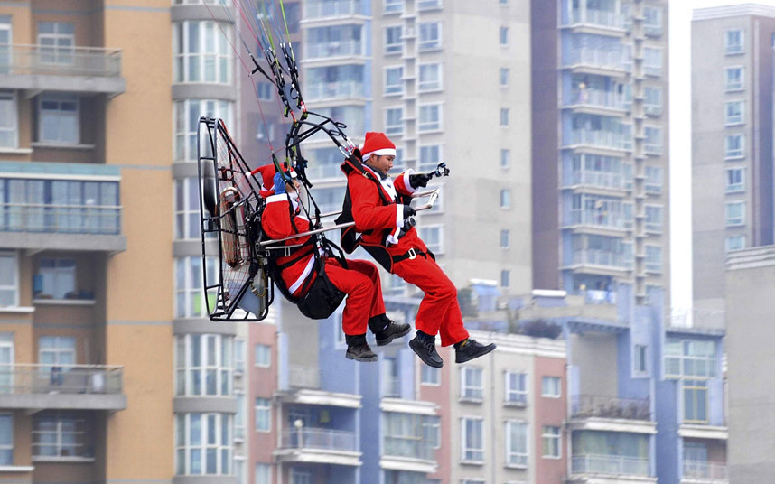 Члены аэроклуба «Паралёт» в костюмах Санта-Клауса сбросили рождественские подарки пешеходам в городе Гуйян