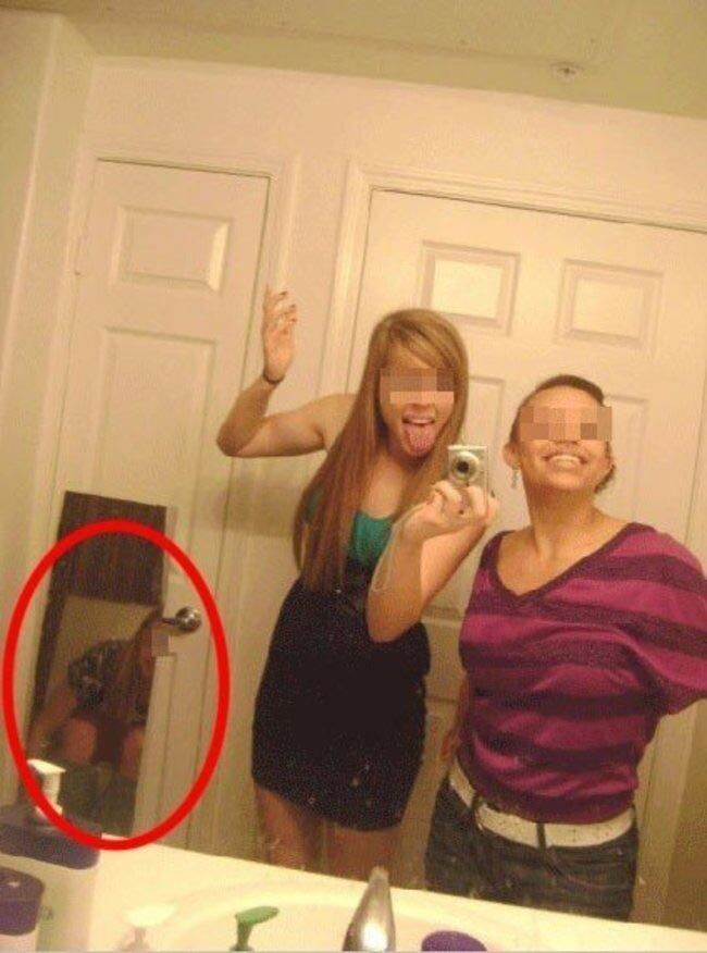 Девочка фотографирует себя в зеркале