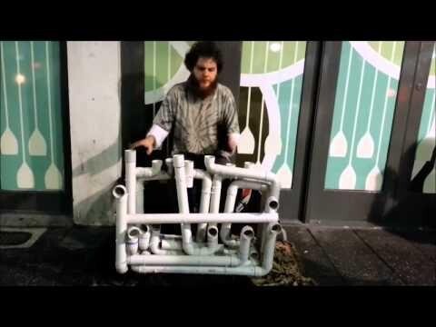 Талантливый уличный музыкант играет на водопроводных трубах 