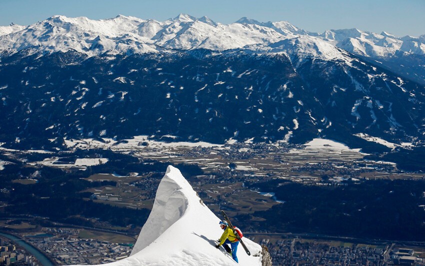 Лыжник взбирается на вершину горы Зеегрубе, которая возвышается над австрийским городом Инсбрук.