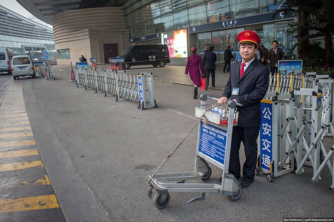 Начнем с вокзалов. Китайский носильщик ждет клиентов. Все сотрудники ходят в костюмах и вообще очень опрятные и аккуратные.