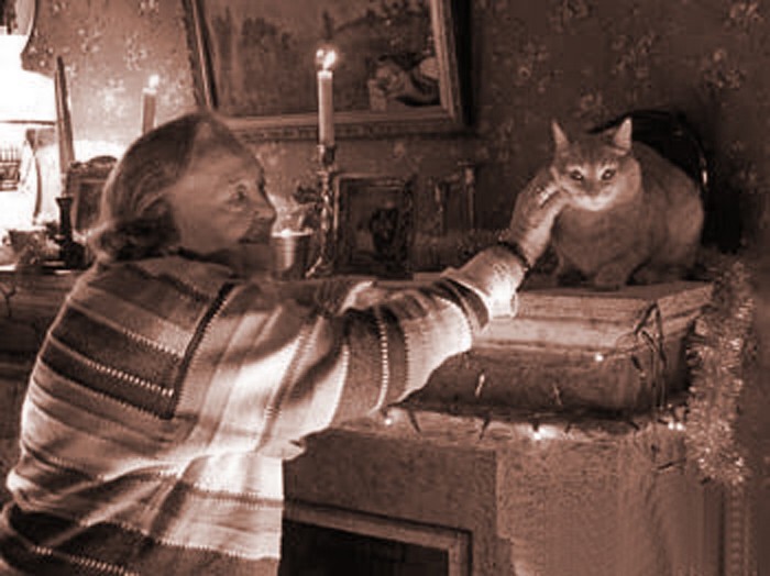 Отложив все дела и присев за столом, В доме бабка беседует с рыжим котом.