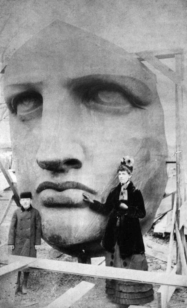 Люди позируют рядом с распакованной статуей Свободы (1886)