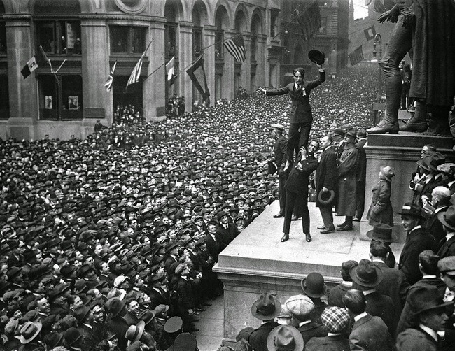 Дуглас Фербенкс держит Чарли  Чаплина перед огромной толпой во время рекламной компании облигаций, выпущенных в США во время Первой мировой войны с целью поддержки действий Антанты, 1918 г.