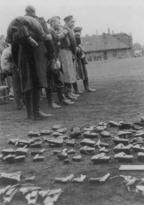 Варшавские повстанцы Армии Крайовой (Armia Krajowa) сдают пистолеты после капитуляции.